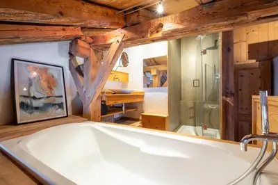a bath tub in a room with a wooden ceiling at Authenthic Chalet Ski on Les Houches Chamonix in Les Houches