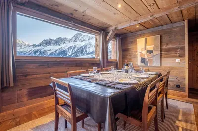 a dining room with a table and a large window at Authenthic Chalet Ski on Les Houches Chamonix in Les Houches