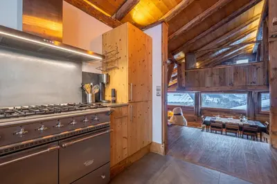 a kitchen with a stove and a dining room at Authenthic Chalet Ski on Les Houches Chamonix in Les Houches
