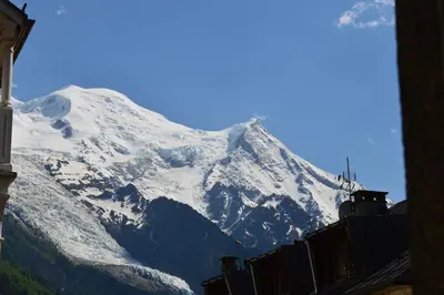a snow covered mountain in front of a building at Villa Léon in Chamonix-Mont-Blanc