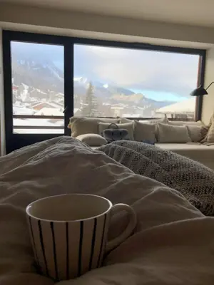 a coffee cup sitting on a bed in a living room at Apartment WABI-SABI by JAPANDI home in Megève