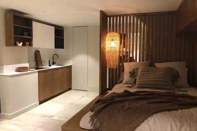 a bedroom with a large bed and a kitchen at Apartment WABI-SABI by JAPANDI home in Megève