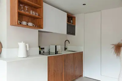 a kitchen with white walls and wooden cabinets at Apartment WABI-SABI by JAPANDI home in Megève