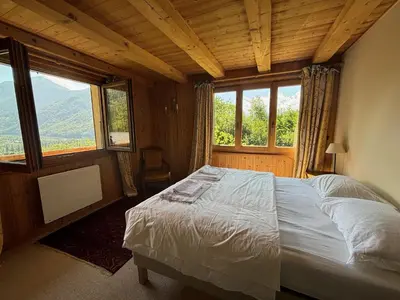 a bedroom with a bed in a room with windows at Chalet du grand cerf in Servoz