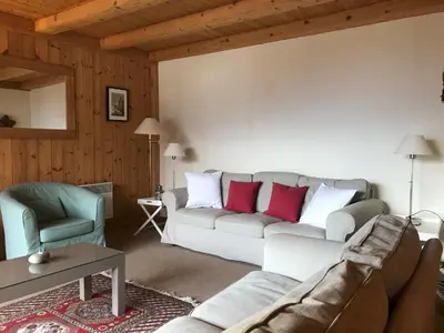 a living room with a couch and a chair at Chalet du grand cerf in Servoz