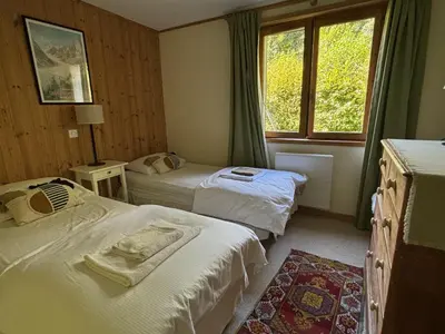 a hotel room with two beds and a window at Chalet du grand cerf in Servoz