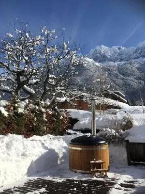 a wooden hot tub in the snow with a bench at Chalet Plan Glacier in Chamonix-Mont-Blanc