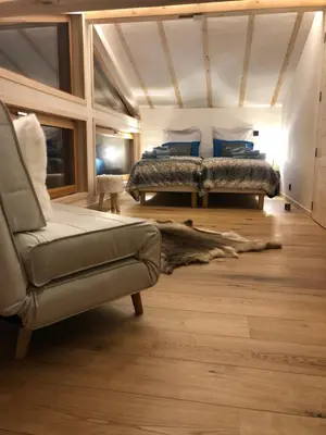 a bedroom with two beds and a chair and a couch at Chalet Plan Glacier in Chamonix-Mont-Blanc