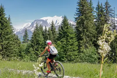 a woman riding a bike in a field at Elegant historic apartment Le Mont Joly - 3 bed 2bath view 80m2 in Saint-Gervais-les-Bains