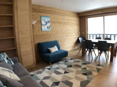 a living room with a blue chair and a table at Snow Rabbit Lodge in Chamonix-Mont-Blanc