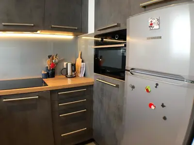 a kitchen with a refrigerator with magnets on it at Snow Rabbit Lodge in Chamonix-Mont-Blanc