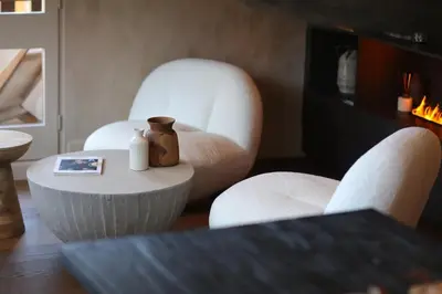 a living room with two white chairs and a table at Apartment FERRONNE by JAPANDI home in Megève