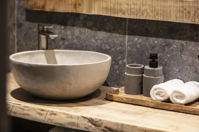 a bathroom sink with a bowl on a wooden counter at Apartment FERRONNE by JAPANDI home in Megève