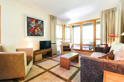 a living room with two couches and a television at Spacious Family 2-bed, 2-bath with parking, private piste in Flaine