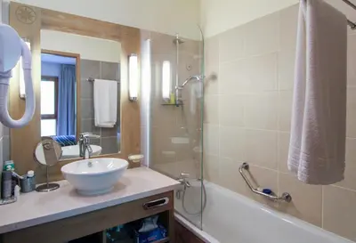 a bathroom with a sink and a tub and a mirror at Spacious Family 2-bed, 2-bath with parking, private piste in Flaine