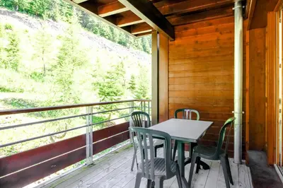 a table and chairs on the porch of a cabin at Spacious Family 2-bed, 2-bath with parking, private piste in Flaine