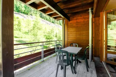 a table and chairs on the balcony of a cabin at Spacious Family 2-bed, 2-bath with parking, private piste in Flaine