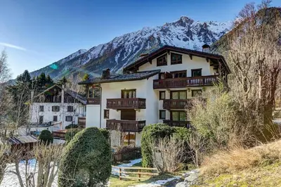 a building with a mountain in the background at MGM Parc Couttet in Chamonix-Mont-Blanc
