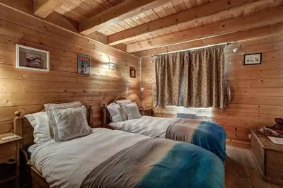 a bedroom with two beds in a log cabin at MGM Parc Couttet in Chamonix-Mont-Blanc
