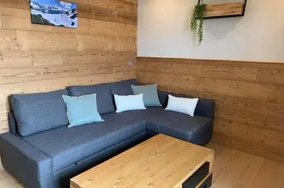 a blue couch with pillows and a table in a room at *** Le Refuge *** Logement standing Megève in Demi-Quartier