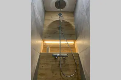 a shower in a bathroom with wooden floors at *** Le Refuge *** Logement standing Megève in Demi-Quartier