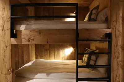 two bunk beds in a room with wooden walls at Apartment NAVAJO by JAPANDI home in Megève