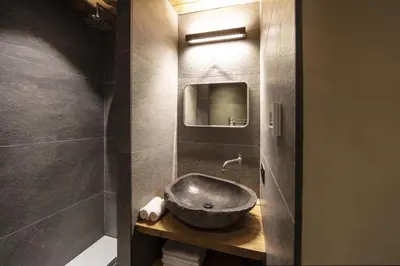 a bathroom with a sink and a mirror at Apartment NAVAJO by JAPANDI home in Megève