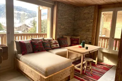 a living room with a couch and a table on a porch at Apartment NAVAJO by JAPANDI home in Megève
