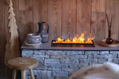 a fireplace in a room with a brick wall at Apartment NAVAJO by JAPANDI home in Megève