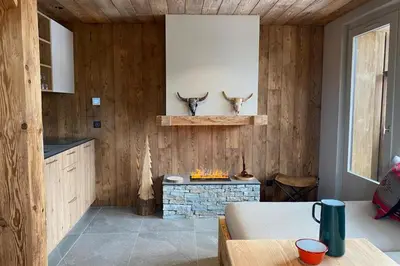 a kitchen with wood paneling and a fireplace with horns on the wall at Apartment NAVAJO by JAPANDI home in Megève