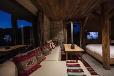 a bedroom with a couch and a bed and windows at Apartment NAVAJO by JAPANDI home in Megève