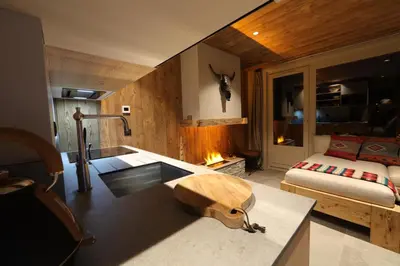 a bedroom with a bed and a desk with a fireplace at Apartment NAVAJO by JAPANDI home in Megève