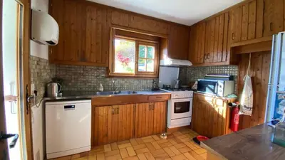 a living room with a fireplace and a chair at Chalet familial à Megève, vue sur le village in Megève