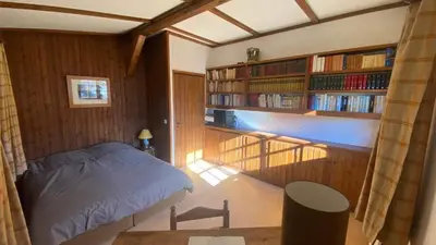 a bedroom with a white bed and a wooden wall at Chalet familial à Megève, vue sur le village in Megève