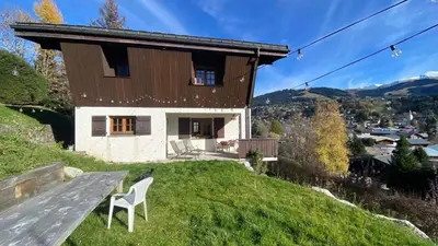 a house with a view of a town and mountains at Chalet familial à Megève, vue sur le village in Megève