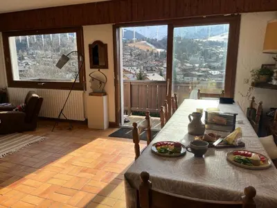 a kitchen with wooden cabinets and a stove top oven at Chalet familial à Megève, vue sur le village in Megève