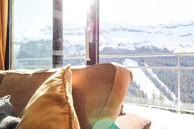 a couch sitting in front of a large window at Penthouse 3-bedroom apartment, mountain views, large terrasse, piste access in Flaine