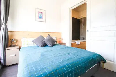 a bedroom with a bed with a blue comforter at Penthouse 3-bedroom apartment, mountain views, large terrasse, piste access in Flaine