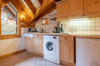 a kitchen with a washing machine in a kitchen at Le Hameau des Neiges in Les Houches