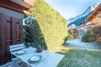 a white table with plates on it on a patio at Le Hameau des Neiges in Les Houches