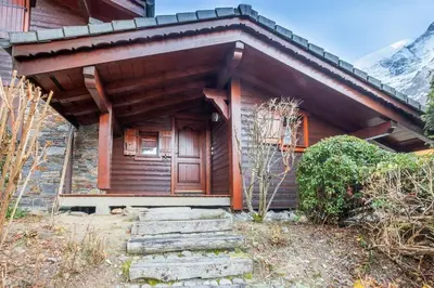 a wooden house with stairs in front of it at Le Hameau des Neiges in Les Houches