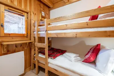 a bedroom with two bunk beds in a cabin at Le Hameau des Neiges in Les Houches