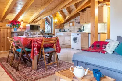 a kitchen and dining room with a table in a cabin at Le Hameau des Neiges in Les Houches