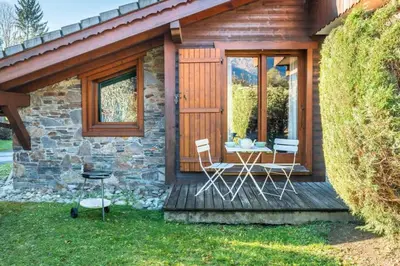 a cabin with a table and chairs on a deck at Le Hameau des Neiges in Les Houches