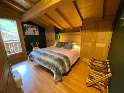 a bedroom with a bed in a room with wooden ceilings at Chalet Megeve, idéal familles proche ski et centre village in Megève