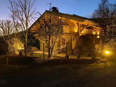 a house with lights on the side of it at Chalet Megeve, idéal familles proche ski et centre village in Megève