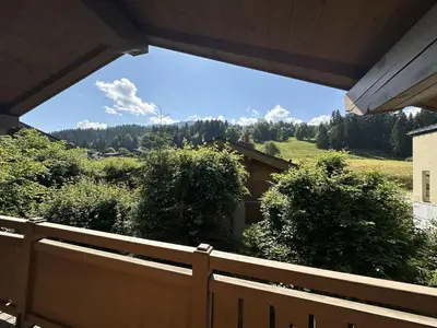 a wooden fence with a view of a house at Chalet Megeve, idéal familles proche ski et centre village in Megève