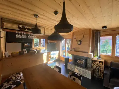 a dining room with a table and a fireplace in a cabin at Chalet Megeve, idéal familles proche ski et centre village in Megève