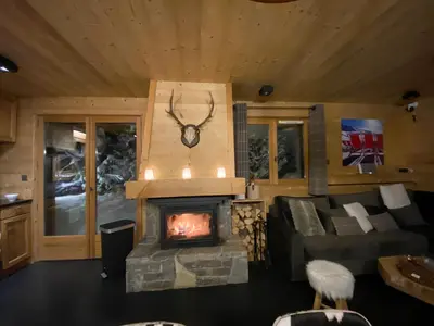 a living room with a couch and a fireplace at Chalet Megeve, idéal familles proche ski et centre village in Megève