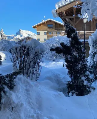 a snow covered yard in front of a house at Chalet Megeve, idéal familles proche ski et centre village in Megève
